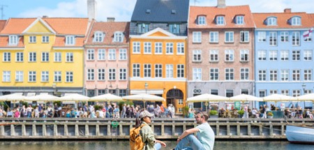 Koppel ontspant in Nyhavn, Kopenhagen, Denemarken in de zon.