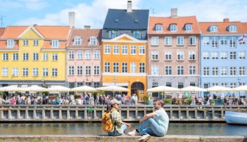 Koppel ontspant in Nyhavn, Kopenhagen, Denemarken in de zon.