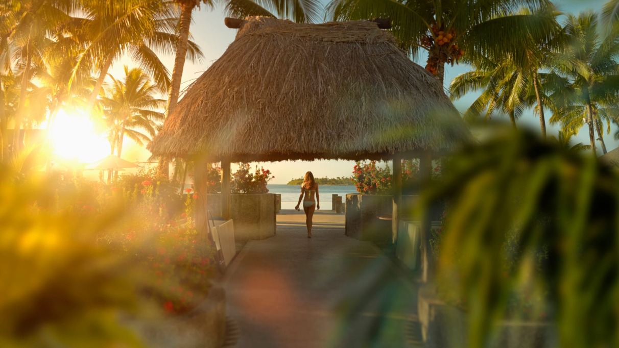Vrouwelijke toerist wandelt onder een hut op een tropisch strand