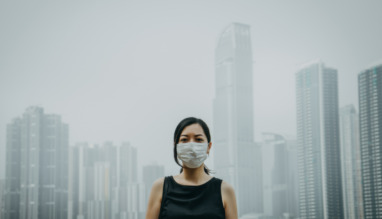 Jonge vrouw draagt masker tegen luchtvervuiling