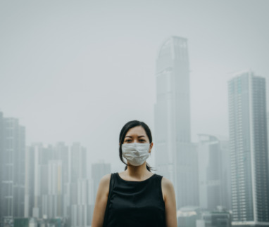 Jonge vrouw draagt masker tegen luchtvervuiling