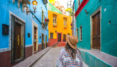 Vrouwelijke toerist loopt door de kleurrijke straatjes in Guanajuato, Mexico