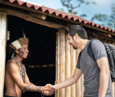 Tourist schudt de hand van een inheemse man in Brazilië