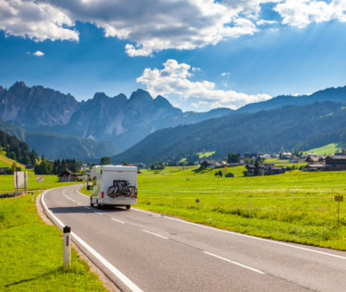 Een camper rijd over een Alpenweg in Oostenrijk
