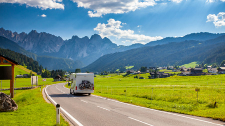Een camper rijd over een Alpenweg in Oostenrijk