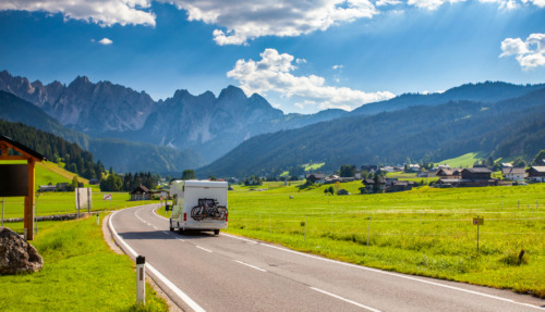 Een camper rijd over een Alpenweg in Oostenrijk