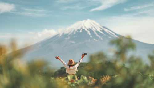 Blije reizigster staat met armen gespreid bij Kawaguchiko meer met Mount Fuji op de achtergrond in Japan