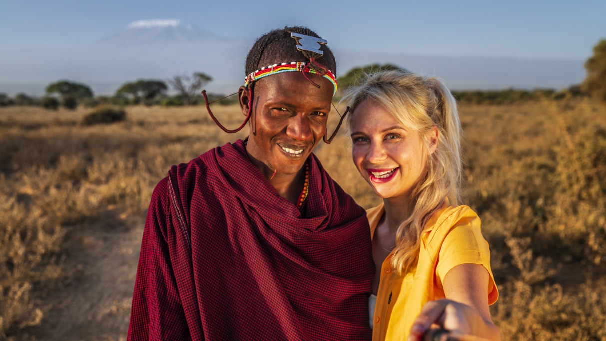 Blanke blonde vrouw met selfie met Masai-man in Kenia