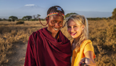 Blanke blonde vrouw met selfie met Masai-man in Kenia