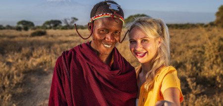 Blanke blonde vrouw met selfie met Masai-man in Kenia