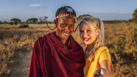 Blanke blonde vrouw met selfie met Masai-man in Kenia