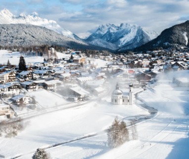 Winterpanorama van Seefeld met het Seekirchl en besneeuwde bergen in Tirol, Oostenrijk