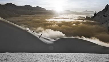Twee skiërs dalen af door diepe sneeuw met uitzicht op de Alpen in de Arlberg, Oostenrijk