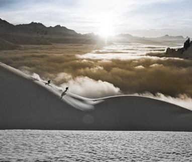 Twee skiërs dalen af door diepe sneeuw met uitzicht op de Alpen in de Arlberg, Oostenrijk