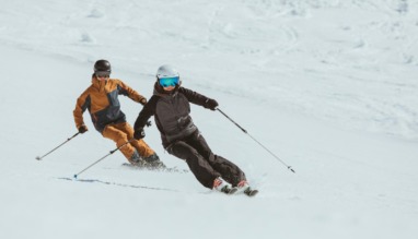 Twee skiërs carven synchroon door de sneeuw in de Arlberg, Oostenrijk