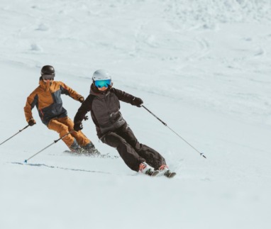 Twee skiërs carven synchroon door de sneeuw in de Arlberg, Oostenrijk