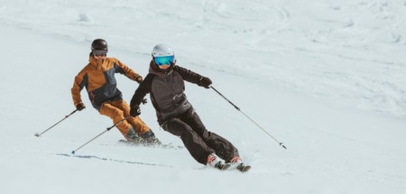 Twee skiërs carven synchroon door de sneeuw in de Arlberg, Oostenrijk