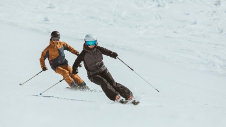 Twee skiërs carven synchroon door de sneeuw in de Arlberg, Oostenrijk