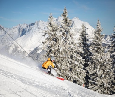 Skiër in actie op de besneeuwde pistes van St. Johann in Tirol met uitzicht op de Wilder Kaiser, Kitzbüheler Alpen