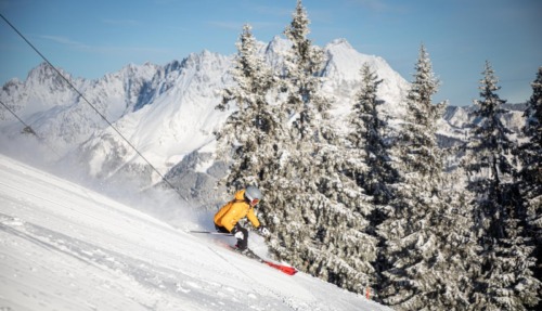 Skiër in actie op de besneeuwde pistes van St. Johann in Tirol met uitzicht op de Wilder Kaiser, Kitzbüheler Alpen