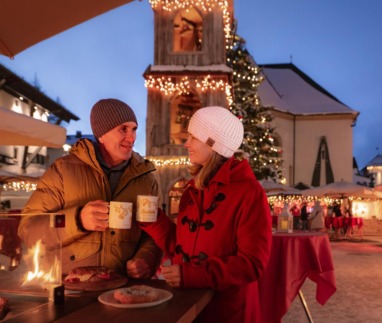 Stel geniet van glühwein en lekkernijen op de sfeervolle kerstmarkt in Seefeld, Oostenrijk