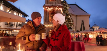 Stel geniet van glühwein en lekkernijen op de sfeervolle kerstmarkt in Seefeld, Oostenrijk