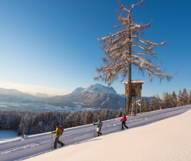 Wandelaars in de sneeuw in St. Johann in Tirol met uitzicht op de Wilder Kaiser in de Kitzbüheler Alpen