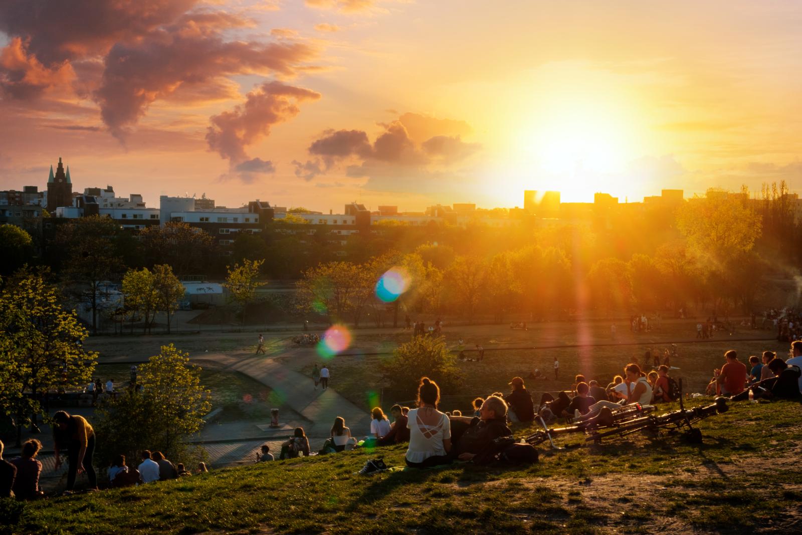 Mensen relaxen op de heuvel van Mauerpark in Berlijn tijdens een zonnige zonsondergang.