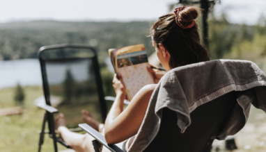 Vrouw puzzelt met kruiswoordraadsel in de tuin