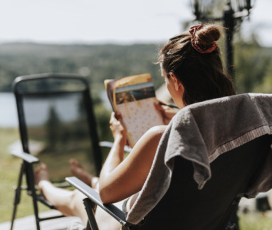 Vrouw puzzelt met kruiswoordraadsel in de tuin