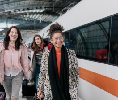 Drie vrouwen lopen op Duits treinstation om de Deutsche Bahn te nemen