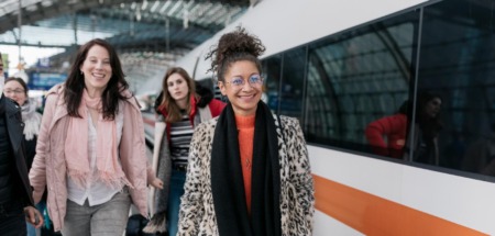 Drie vrouwen lopen op Duits treinstation om de Deutsche Bahn te nemen