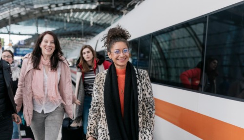 Drie vrouwen lopen op Duits treinstation om de Deutsche Bahn te nemen