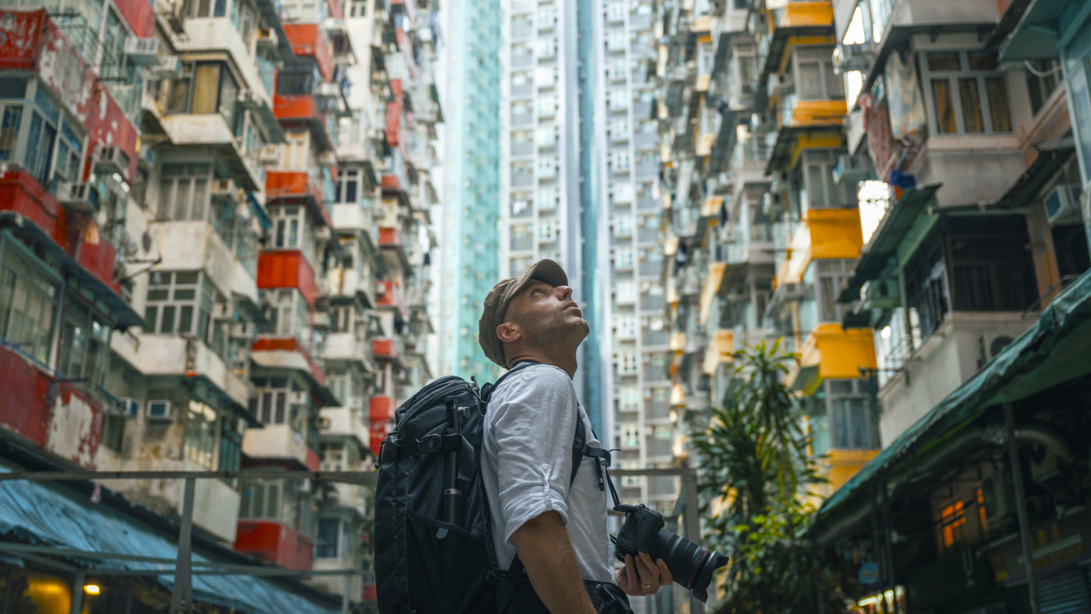 Mannelijke toerist met camera loopt door de straten van Hongkong