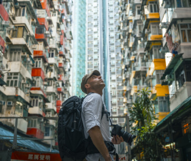 Mannelijke toerist met camera loopt door de straten van Hongkong