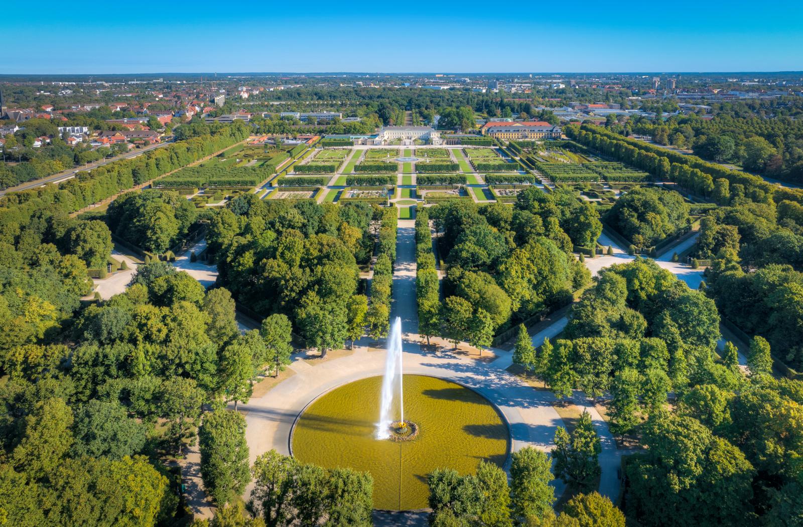 Luchtfoto van de Großer Garten in Hannover, Duitsland, met barokke tuinen, fonteinen en het Herrenhausen-paleis.