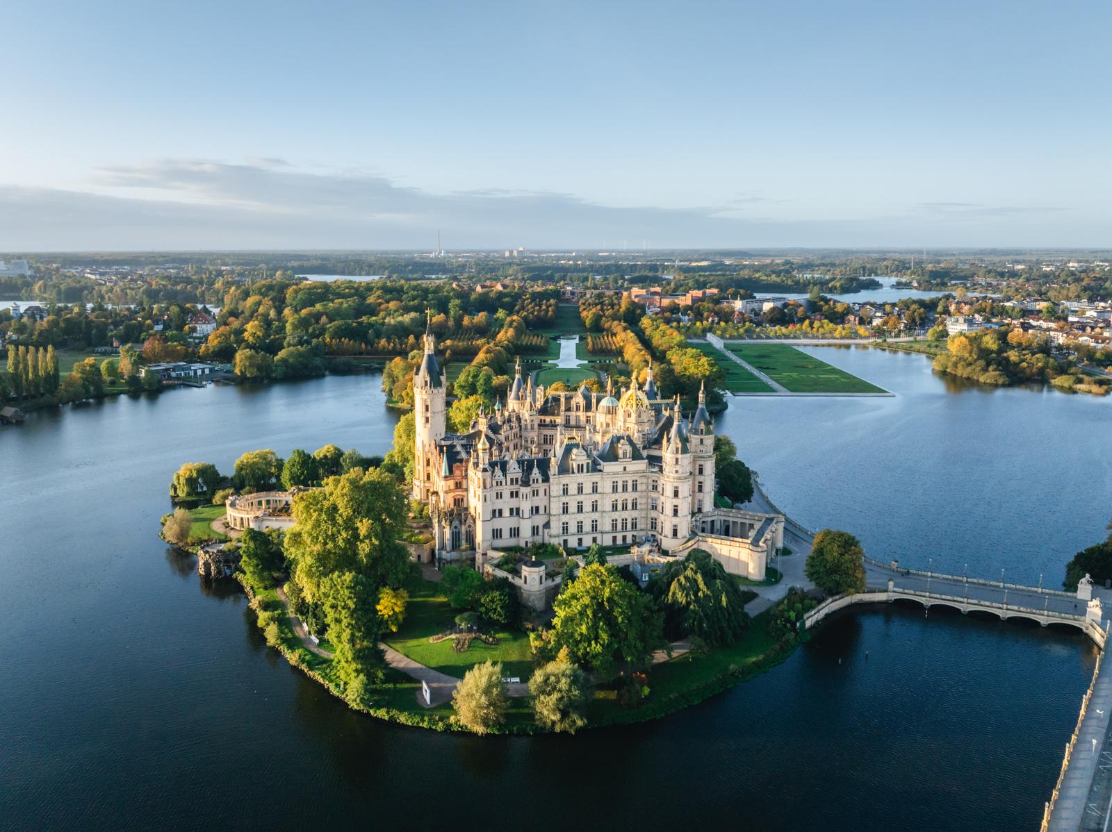 Luchtfoto van Slot Schwerin op een eiland in het meer, omringd door tuinen en water