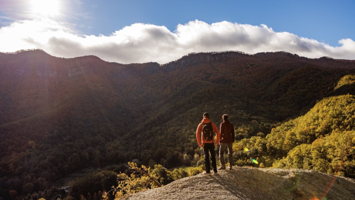 Twee wandelaars kijken uit over de groene en kleurrijke berghellingen van de Pyreneeën van Girona in Spanje