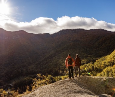 Twee wandelaars kijken uit over de groene en kleurrijke berghellingen van de Pyreneeën van Girona in Spanje