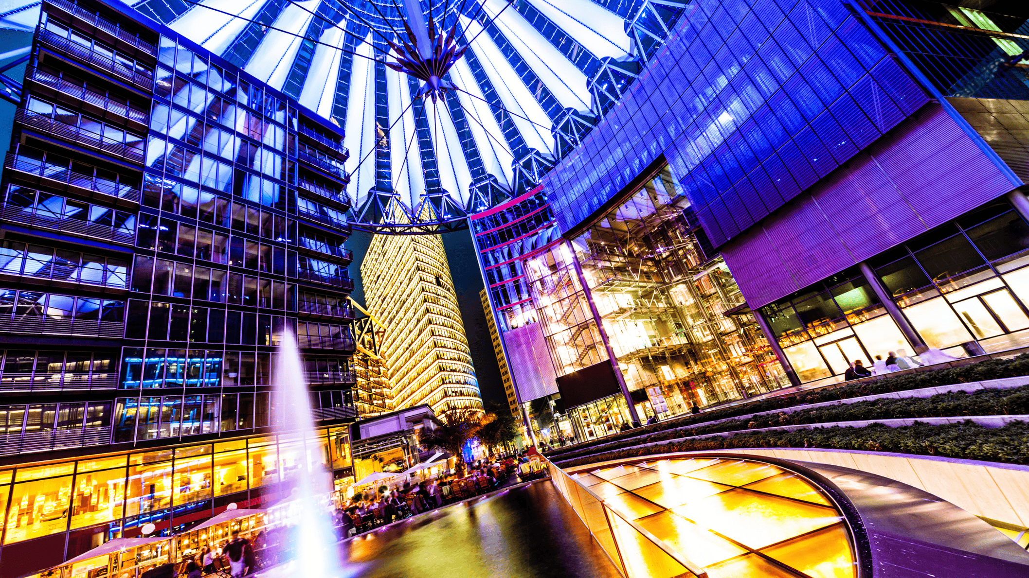 Het verlichte Sony Center in Berlijn bij nacht met moderne architectuur en kleurrijke lichtkoepel.
