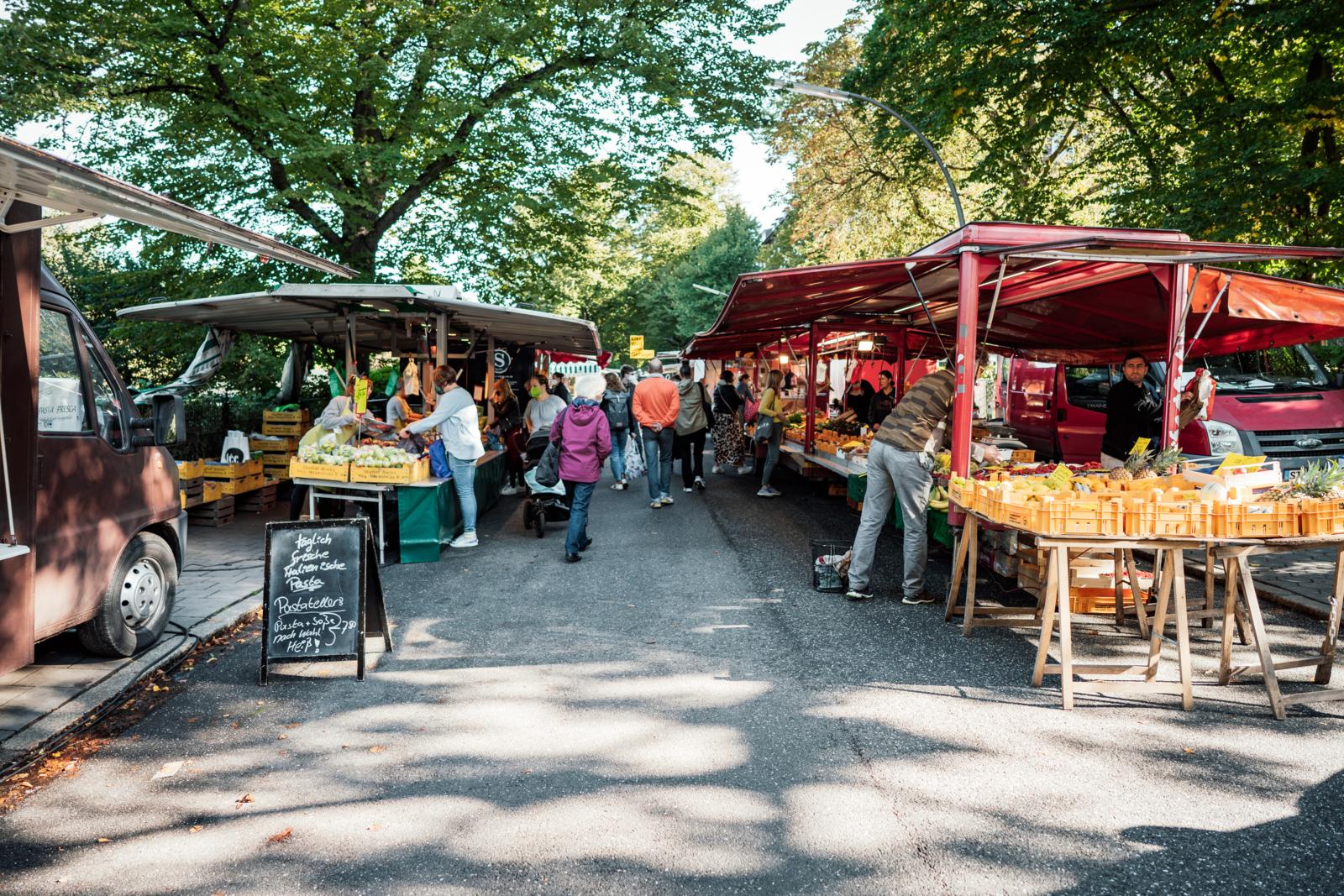 Straatmarkt met groente- en fruitkraampjes onder bomen in Hamburg, Duitsland.
