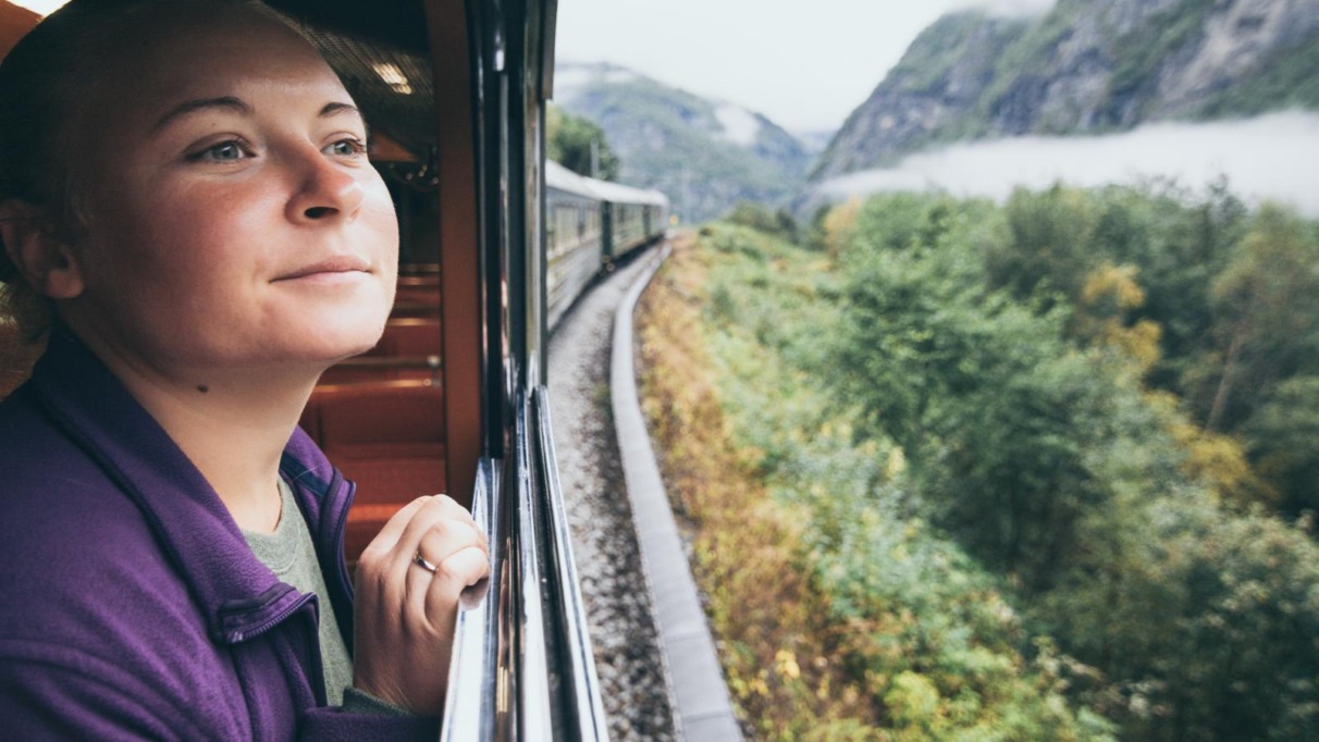 Vrouw kijkt uit het raam van een trein in Noorwegen