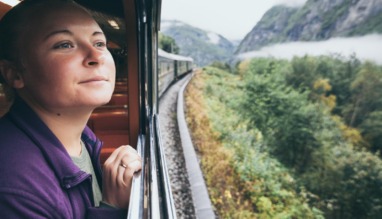 Vrouw kijkt uit het raam van een trein in Noorwegen
