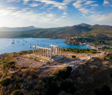De Tempel van Poseidon bij Kaap Sounion met uitzicht op de Egeïsche Zee en zeilboten.