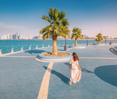 Vrouw wandelt op boulevard en kijkt uit over Abu Dhabi, uitgeroepen tot gelukkigste stad ter wereld in 2025 volgens Time Out
