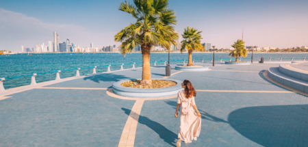 Vrouw wandelt op boulevard en kijkt uit over Abu Dhabi, uitgeroepen tot gelukkigste stad ter wereld in 2025 volgens Time Out