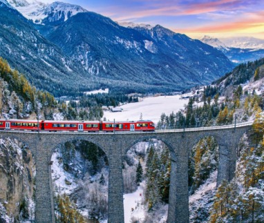 Trein rijdt over viaduct in Zwitserland in de winter