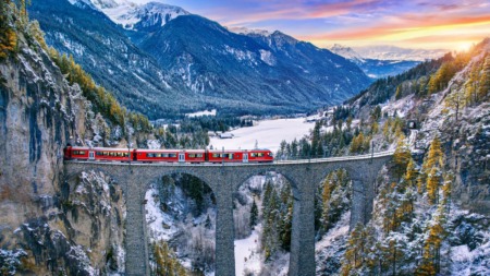 Trein rijdt over viaduct in Zwitserland in de winter