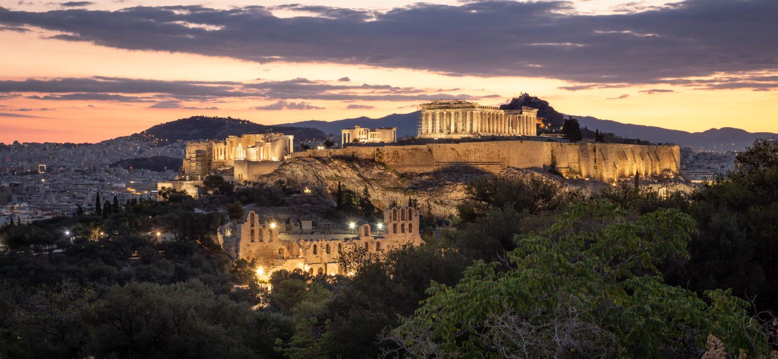 De verlichte Akropolis met het Parthenon in Athene tijdens zonsondergang.