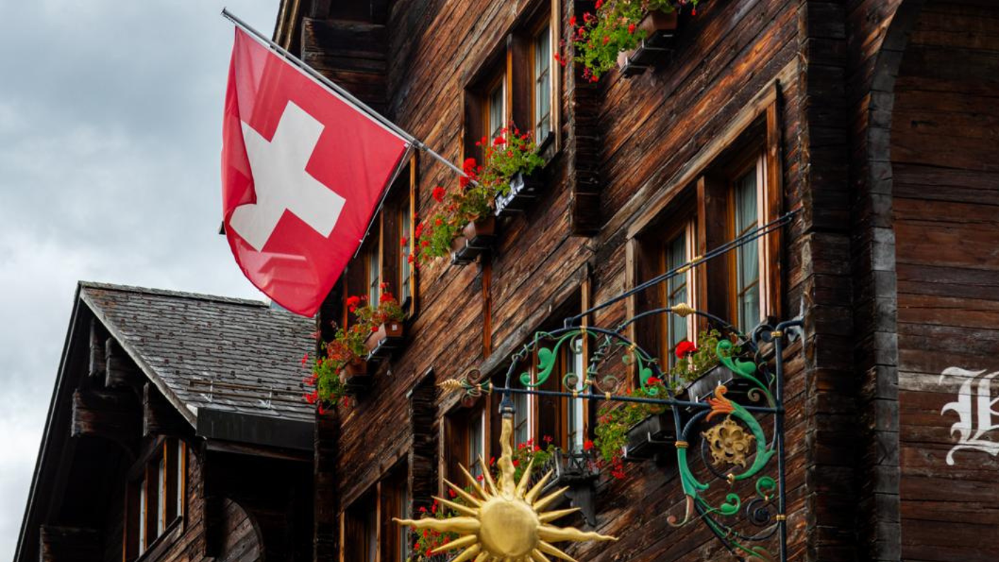 Zwitsers hotel met vlag en houten gevel.